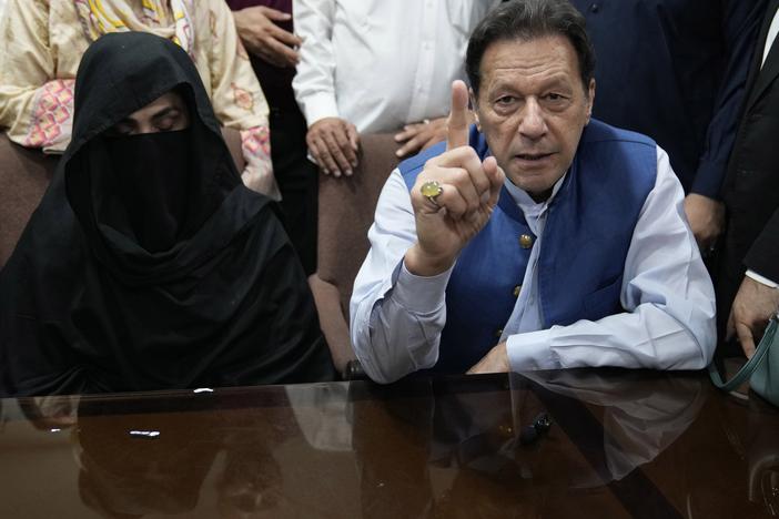 Pakistan's former Prime Minister Imran Khan, right, with his wife Bushra Bibi, speaks to the media before signing documents to submit surety bond over his bails in different cases, at an office of Lahore High Court in Lahore, Pakistan, on July 17, 2023.