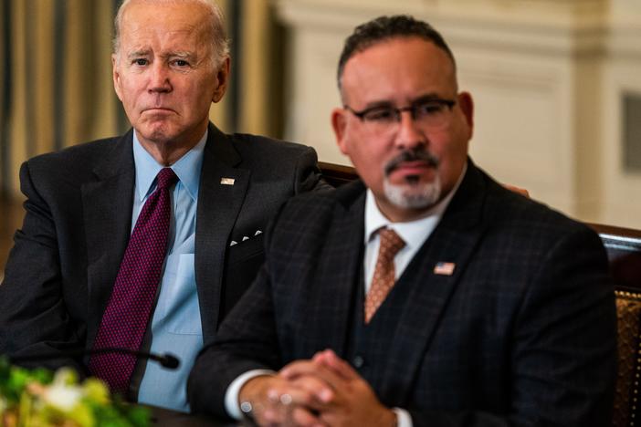 President Joe Biden pictured with his Department of Education secretary, Miguel Cardona, in October 2022.