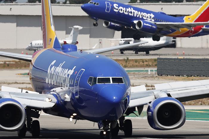 A Southwest Airlines plane takes off as another Southwest jet taxis in Burbank, Calif.