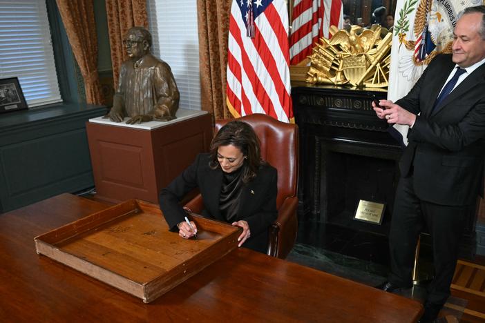Vice President Harris signs the drawer of her desk as second gentleman Doug Emhoff takes a picture on Jan. 16, 2025.