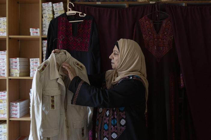 Hanan Zarura, a master craftswoman of Palestinian tatreez embroidery, with a jacket she's been making at her workshop in the Palestinian refugee camp of Shatila, in Beirut, Lebanon.
