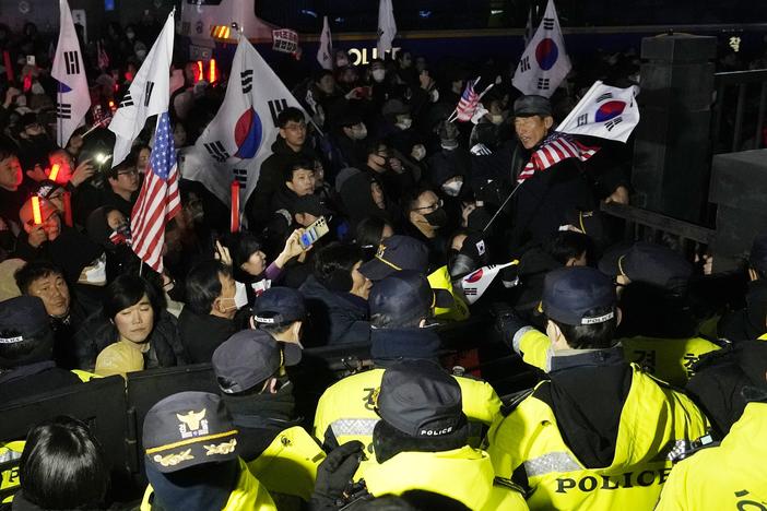 Police officers stand guard as supporters of impeached South Korean President Yoon Suk Yeol try to enter the Seoul Western District Court in Seoul on Saturday, Jan. 18, 2025.
