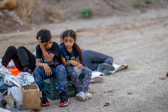 Children of the Rivera family look toward the sky while waiting to be apprehended by U.S. Customs and Border Protection officers after crossing over into the U.S. in June 2024 in Ruby, Ariz.