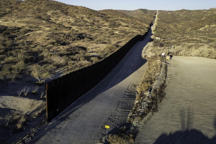 In this aerial view, the U.S.-Mexico border wall ends with a gap on Sunday near Sasabe, Ariz. Although immigrant crossings are down sharply, the incoming Trump administration has vowed to complete the wall and "seal" the border completely.