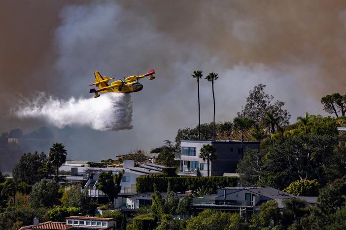 A Super Scooper plane drops water on the Palisades fire on Jan. 7 in Pacific Palisades, Calif.