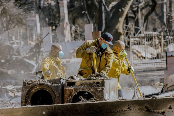Firefighters clean up after the Eaton Fire in California. Health experts recommend wearing particle-filtering masks, goggles, gloves, and other personal protective equipment while cleaning up the potentially toxic ash and smoke after the burn.