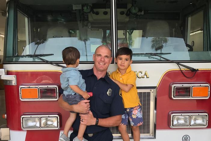 Old photo of fire captain Shane Lawlor and his two sons at a Santa Monica Fire Station. Lawlor has been a firefighter for 17 years. He was dispatched last week to the Pacific Palisades and is still fighting the fires there.