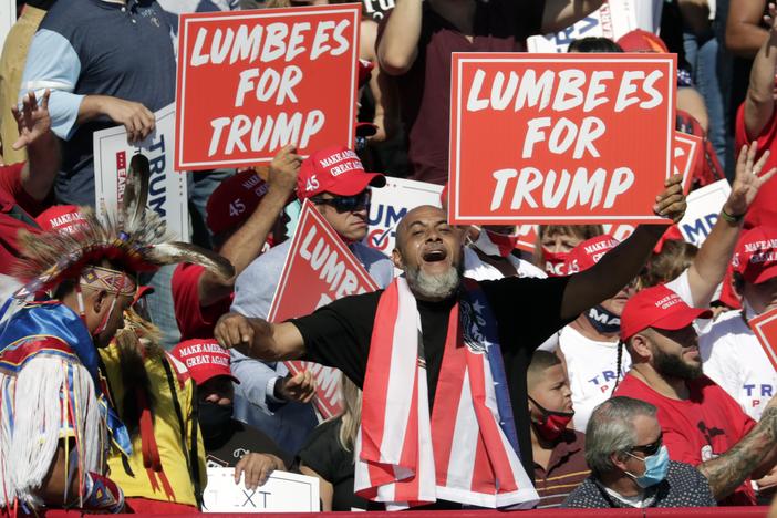 Supporters hold "Lumbees for Trump" signs as President Donald Trump speaks during a campaign rally at the Robeson County Fairgrounds in Lumberton, N.C.