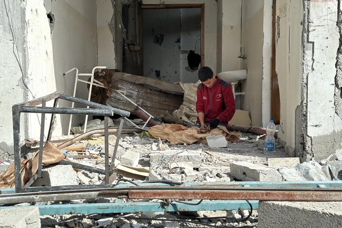 A man sits in the rubble of his destroyed home in Rafah as Palestinians return to the southern Gaza Strip city for the first time in months, after Israeli troops withdrew to the border, Jan. 20.