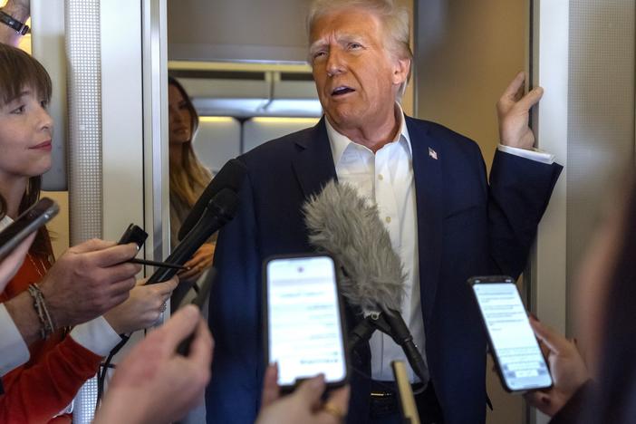 President Donald Trump speaks to reporters aboard Air Force One as he travels from Las Vegas to Miami, on Saturday.