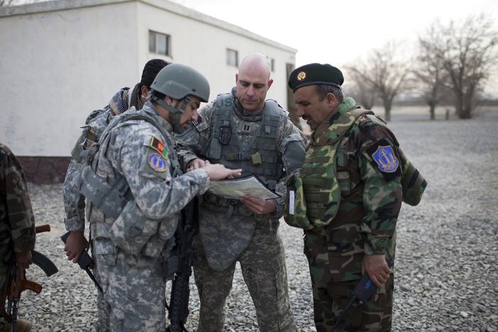 A U.S. Air Force captain goes over the day's mission route map with an Afghan National Army officer with assistance from an Afghan interpreter (left), before the U.S.-Afghan convoy sets off in Ghazni, Afghanistan, on March 16, 2009.