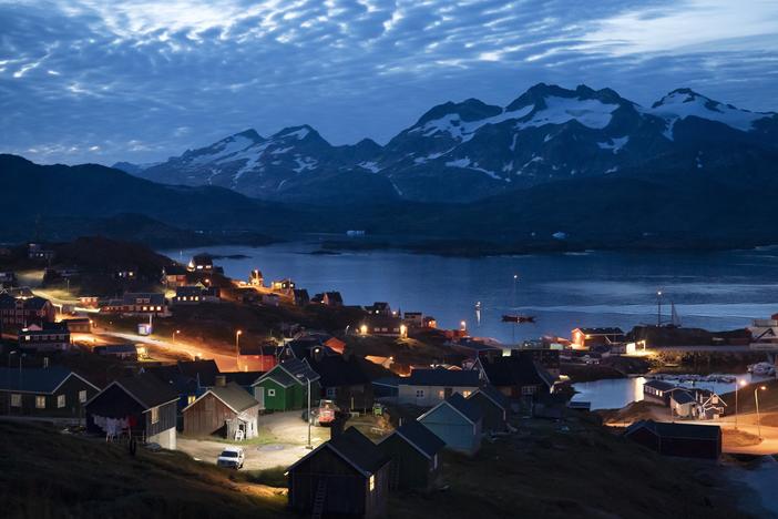 Homes are illuminated after the sunset in Tasiilaq, Greenland, Friday Aug. 16, 2019.