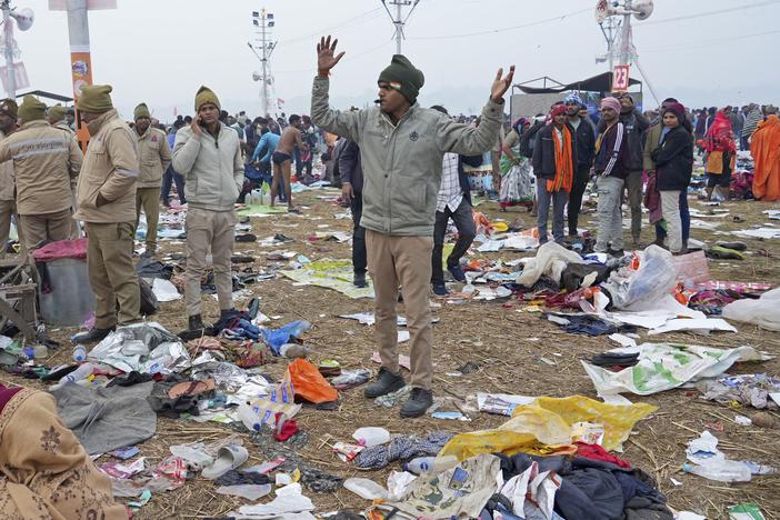 A policeman gestures as the belongings of Hindu devotees lie scattered after a stampede when Hindu devotees rushed to take a holy bath in the Sangam, the confluence of the Ganges, the Yamuna and the mythical Saraswati rivers, on "Mauni Amavasya" or new moon day during the Maha Kumbh festival in Prayagraj, India on Wednesday.