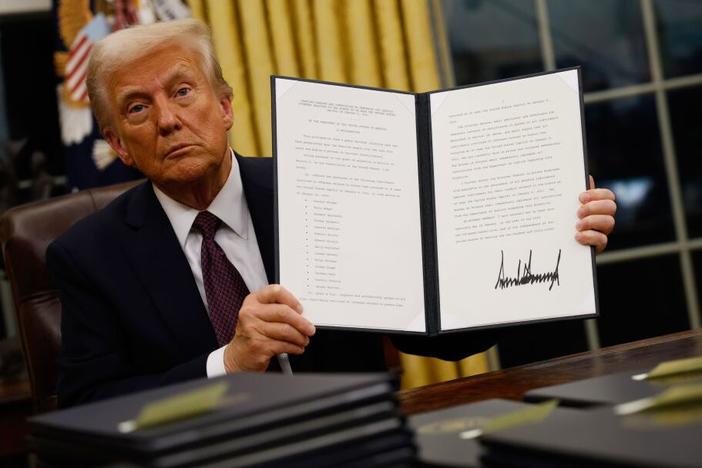 President Trump signs executive orders in the Oval Office on Jan. 20.