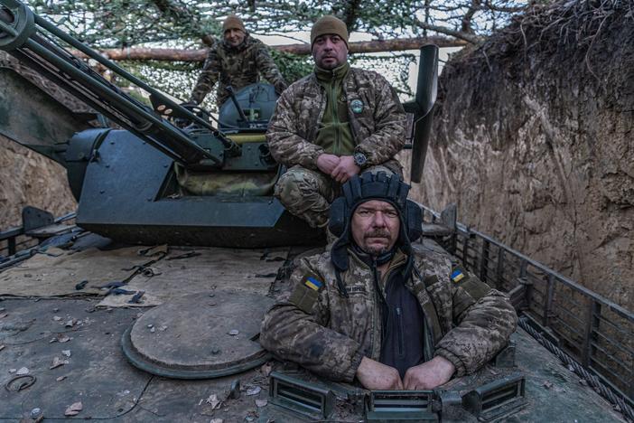 A driver-mechanic with the call sign Molfar (right), the unit's commander call-signed Grizzly (center) and a gunner with the call sign Psycho are on a BMP-1, a modernized Soviet-era infantry fighting vehicle, before a mission to the coast of Dnipro River, in Ukraine's Kherson region, on Jan. 4.