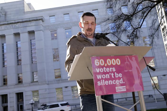 Standing in front of the North Carolina Supreme Court in Raleigh on Jan. 14, Ted Corcoran reads a list of over 60,000 people who cast ballots in the November 2024 election but whose votes have been challenged by Republican court candidate Jefferson Griffin in his extremely close race with Democratic Justice Allison Riggs.
