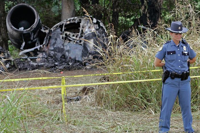 In this Aug. 29, 2006, photo, a police officer guards the wreckage of Comair Flight 5191 at Blue Grass Airport in Lexington, Ky. The crash killed 49 passengers and crew.