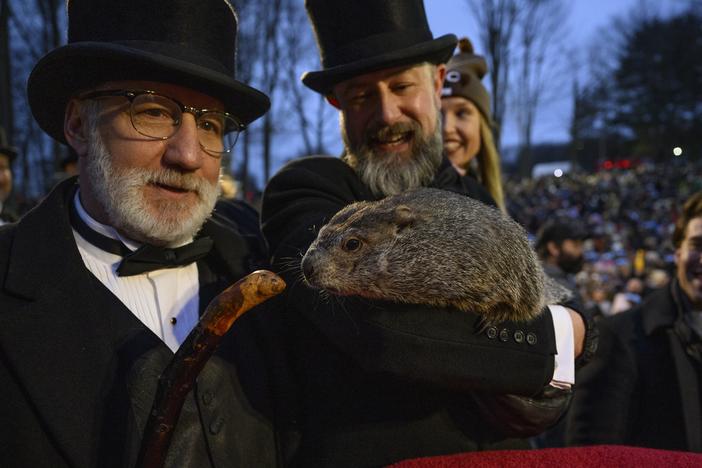 Punxsutawney Phil makes his annual winter forecast to Groundhog Club Inner Circle President Tom Dunkel, left, who looks on as the groundhog is held by A.J. Dereume on Feb. 2, 2024. The Inner Circle's members have "the Groundhog gene," Dereume says.