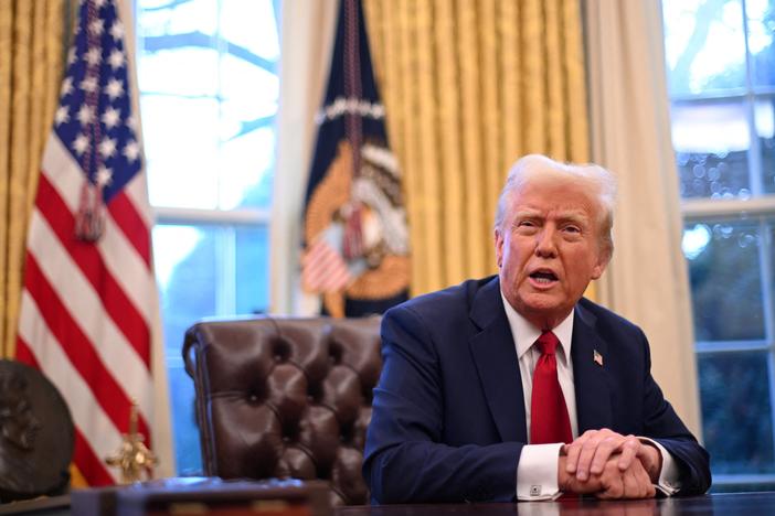 President Trump speaks to journalists in the Oval Office on Friday. A federal judge in Rhode Island has issued an order blocking the administration's efforts to freeze some federal spending.