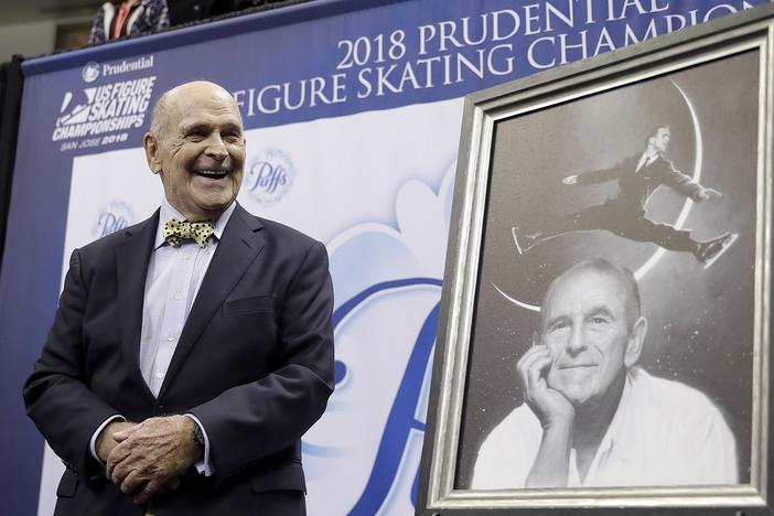 Dick Button smiles next to a painting of him while honored at the U.S. Figure Skating Championships in San Jose, Calif., Thursday, Jan. 4, 2018.