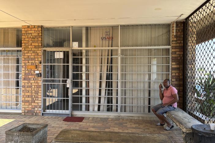 A man sits outside the closed Isizinda Sempilo clinic in the Johannesburg township of Soweto Thursday, Jan. 30.