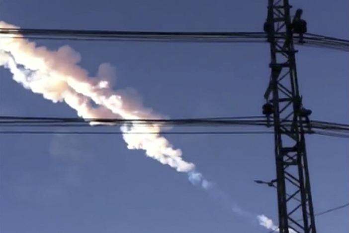 A meteor contrail is seen over Chelyabinsk, Russia on Friday, Feb. 15, 2013, in a photo taken by a mobile phone camera. The object streaked across the sky over Russia's Ural Mountains region causing a shock wave and injuring hundreds of people, including many who were hurt by broken glass.