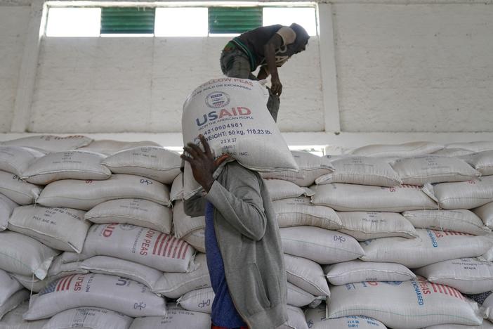 Workers move bags of yellow lentils at an aid operation run by USAID, Catholic Relief Services and the Relief Society of Tigray in Mekele, Ethiopia, on June 16, 2021.