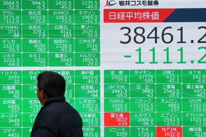 A man looks at the electronic board showing the numbers of the Nikkei Stock Average on the Tokyo Stock Exchange on a street in central Tokyo on February 3, 2025.