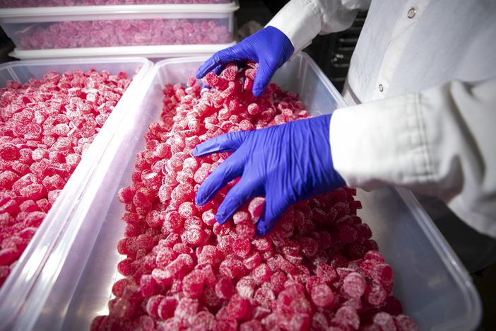 Joe Ciulla handles Ript gummies before they're packaged at the Ripple Cannabis Co.'s production facility in Commerce City, Colo.