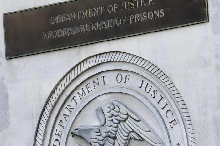 A sign for the Department of Justice Federal Bureau of Prisons is displayed in the Brooklyn borough of New York, July 6, 2020.