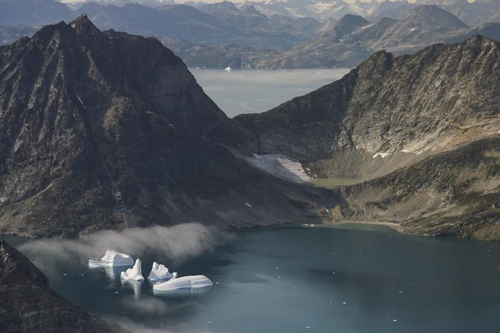 Icebergs are photographed from the window of an airplane carrying NASA scientists as they fly on a mission to track melting ice in eastern Greenland on Aug. 14, 2019.