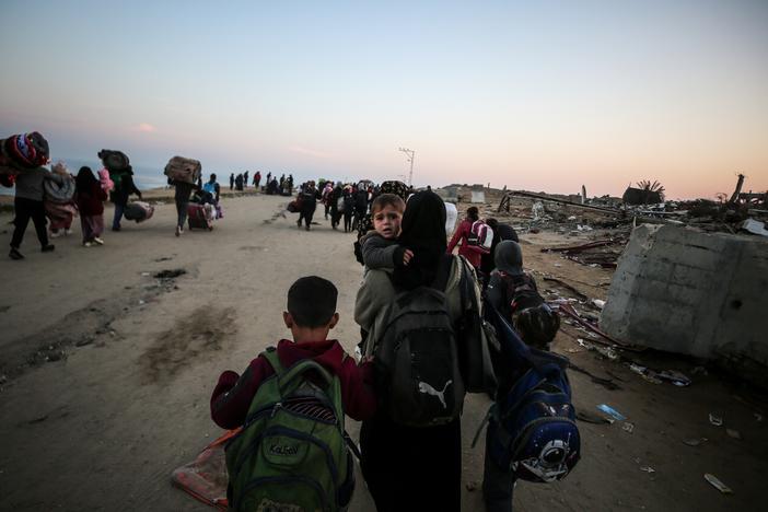 Displaced Palestinians make their way back on foot from the southern Gaza regions to their homes in the north via Al Rashid Road after the ceasefire agreement, Jan. 28.