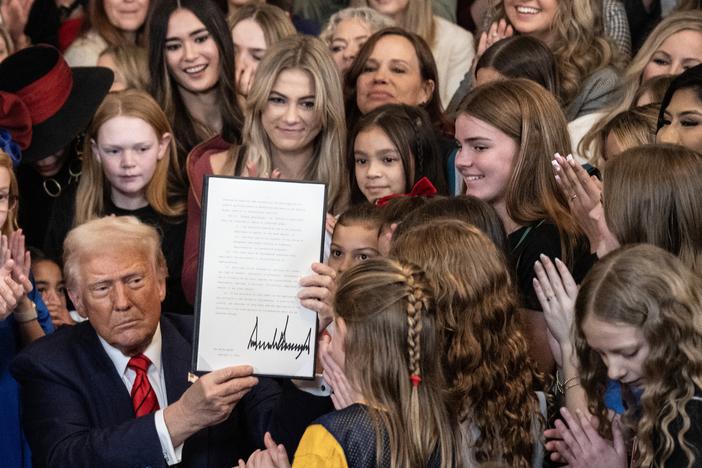 President Trump holds up the "No Men in Women's Sports" executive order after signing it in the East Room of the White House in Washington, D.C., on Feb. 5. It became the latest in a series of executive orders focused on transgender rights, many of which also center on curbing "gender ideology."