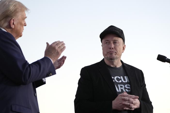 Republican presidential nominee former President Donald Trump, left, claps as Tesla and SpaceX CEO Elon Musk prepares to depart after speaking at a campaign event at the Butler Farm Show, on Oct. 5, 2024, in Butler, Pa.