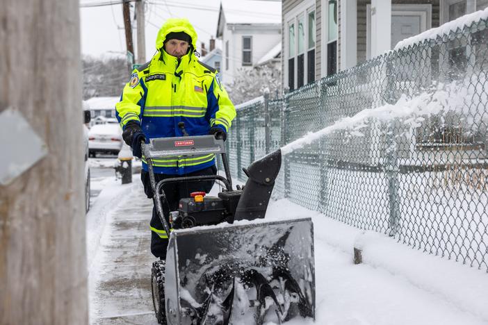 A man uses a snow blower to clear snow in Boston on Sunday.