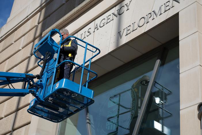 On February 7, a worker removes the U.S. Agency for International Development sign on their headquarters in Washington, D.C.  The Trump administration has targeted with agency with a series of orders that have put its programs and employees in limbo.