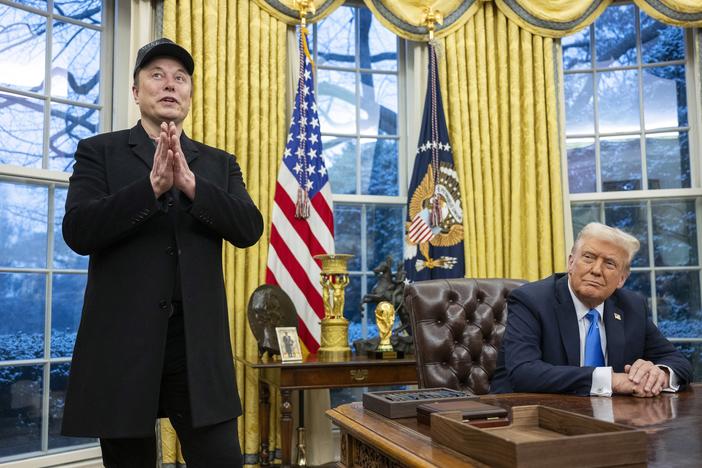 Elon Musk takes questions from reporters as President Trump looks on in the Oval Office of the White House on Tuesday.