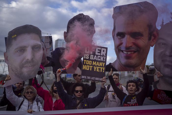 Relatives and supporters of Israelis held hostage in the Gaza Strip hold photos depicting their faces during a protest in Tel Aviv, Israel, on Thursday. They're demanding the release of the hostages from Hamas captivity.
