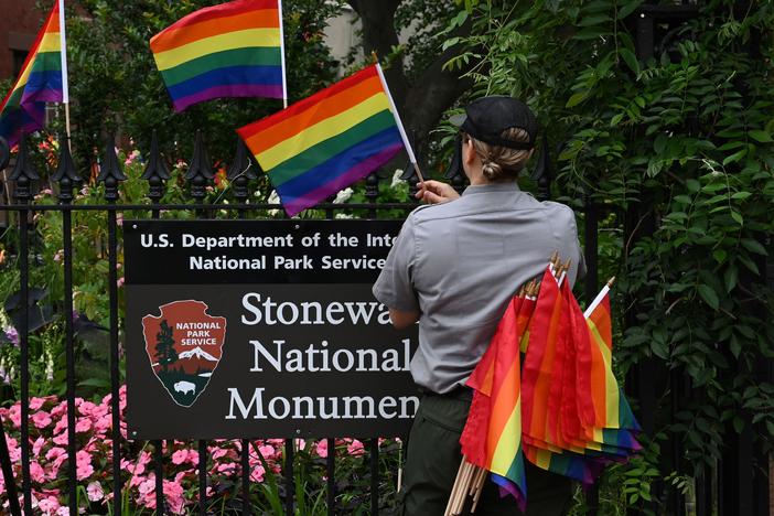 A National Park Service ranger places rainbow flags on the fence at the Stonewall National Monument in the West Village neighborhood of Greenwich Village in Lower Manhattan, New York City, on June 19, 2019.