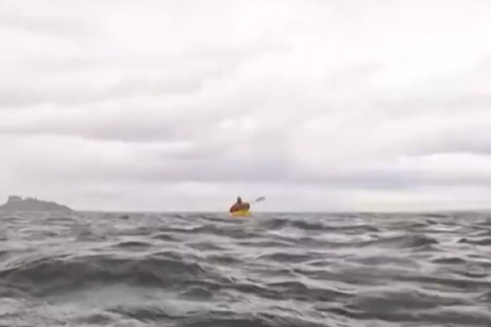 A screenshot of a video from the Associated Press shows Adrián Simancas kayaking in the Strait of Magellan, moments before a whale surfaced and briefly engulfed him.