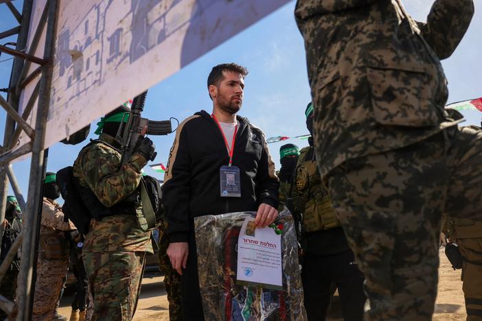 Hamas militants escort Israeli-American hostage Sagui Dekel-Chen on a stage before handing him over to a Red Cross team in Khan Yunis, southern Gaza Strip, on Feb. 15, 2025, as part of the sixth hostage-prisoner exchange.