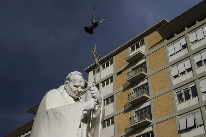 A marble statue of late Pope John Paul II is backdropped on Saturday by the Agostino Gemelli Polyclinic in Rome, where Pope Francis was hospitalized after a weeklong bout of bronchitis worsened.