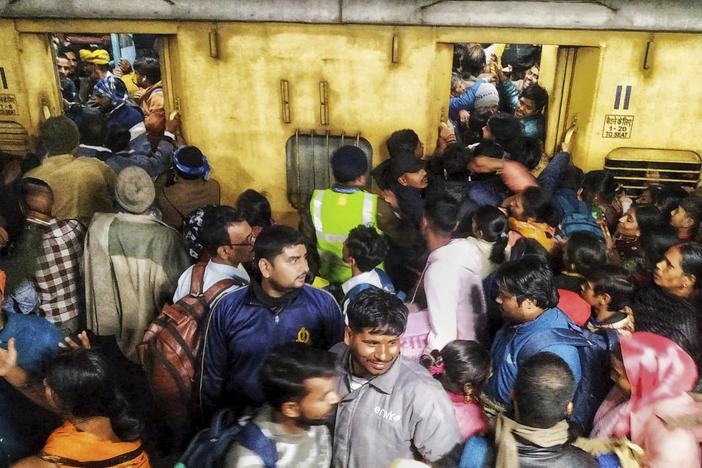 Passengers jostle with each other to board a train at the New Delhi Railway station, in New Delhi, India, Saturday, Feb.15, 2025.