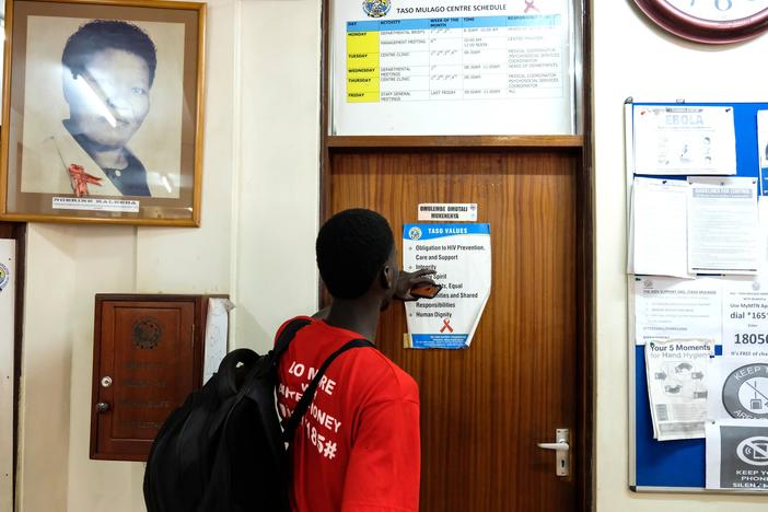 A man reads a poster in the office of The AIDS Support Organization in Kampala, Uganda. Half the group's funding is from the United States Agency for International Development (USAID). The Trump administration froze virtually all foreign aid funds for 90 days, then issued a waiver for life-saving activities. Now a judge has ordered a temporary halt to the freeze.