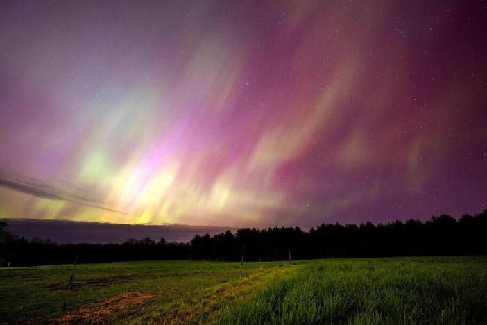 The aurora borealis, commonly called the northern lights, illuminate the sky over a horse pasture in Mercer, Maine on May 10, 2024.