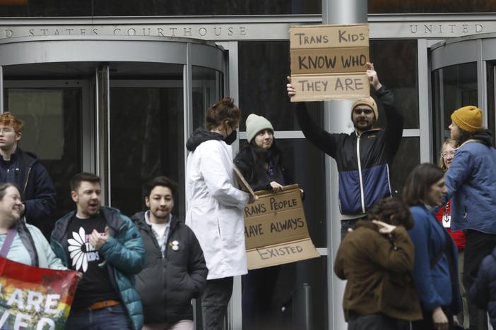 People celebrate outside a Seattle federal courthouse after a second federal judge paused President Trump's order against gender-affirming care for youth on Friday.