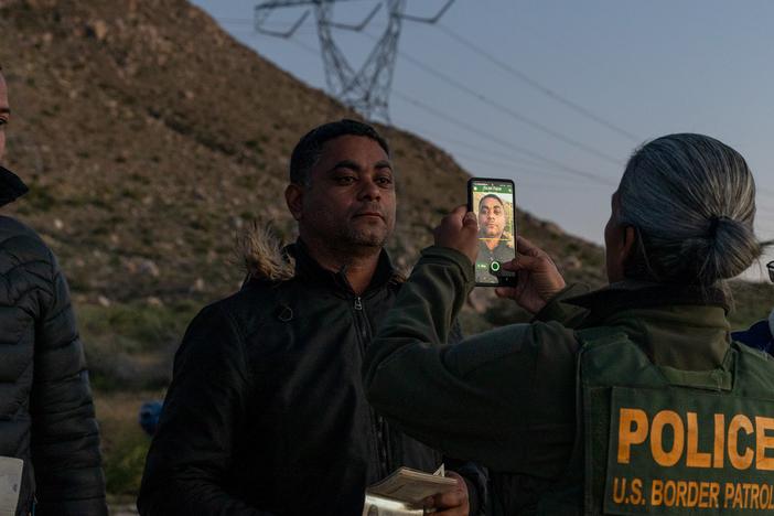 U.S. Customs and Border Protection officials collect facial scans from migrants crossing into the country from the U.S.-Mexico border as part of processing procedures.<br>