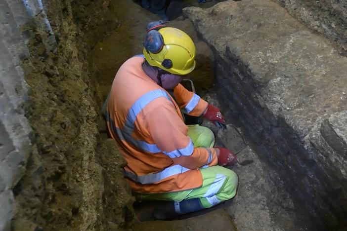 An archaeologist is seen on a screenshot from a video of an excavation in the basement of a building on Gracechurch Street in London's financial district.