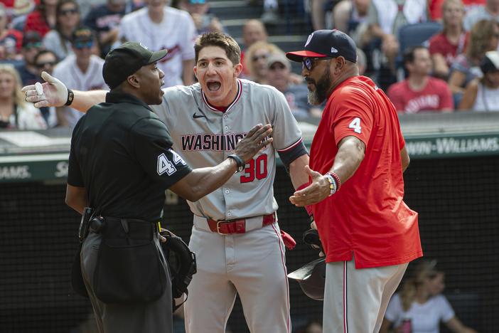 Washington Nationals' Jacob Young (30) argues a called third strike with umpire Malachi Moore, left, as Nationals manager Dave Martinez, right, joins in during the third inning of a baseball game against the Cleveland Guardians in Cleveland on June 1, 2024.