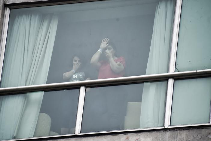 Migrants deported from the United States wave to the press from inside a hotel in Panama City on Wednesday.